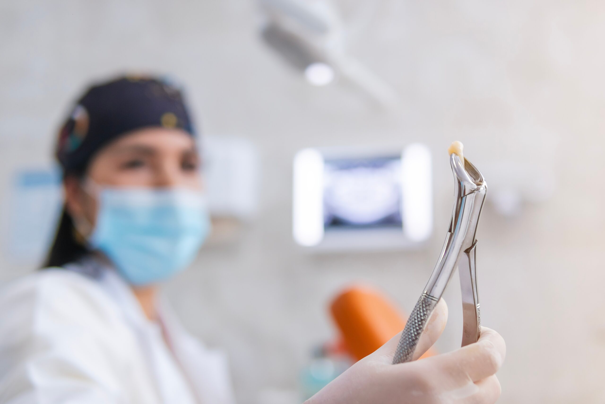 The,Dentist,,Specialized,In,Root,Canal,Treatments,,Smiles,While,Holding tooth extraction